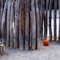 Detail eines Spielplatzes in Lohfelden, roter Ball vor Holzpalisaden