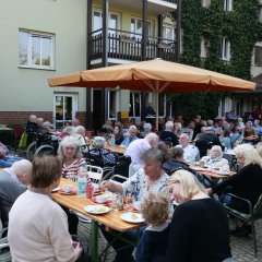 Die Gäste beim gemütlichen Kaffeeklatsch vor dem Seniorenwohnheim.