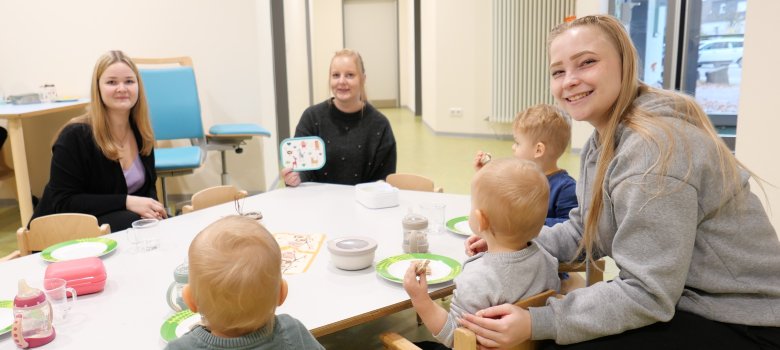 Die angehenden Erzieherinnen Laura Pristl (l.) und Alisa Sußebach (r.) sowie die staatlich anerkannte Erzieherin und Praxisanleitung Lea Martens beim gemeinsamen Frühstück mit den Krippenkindern.