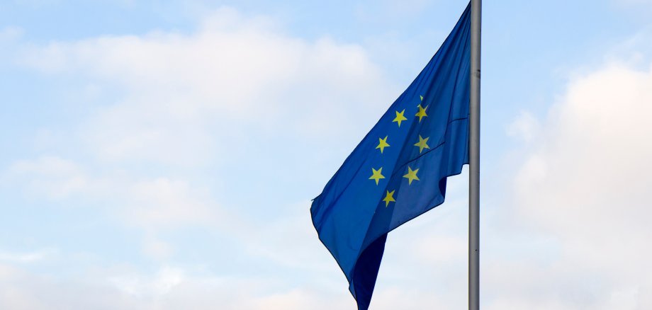 Flagge der Europäischen Union, wehende Fahnen und bewölkter Himmel in Tiflis