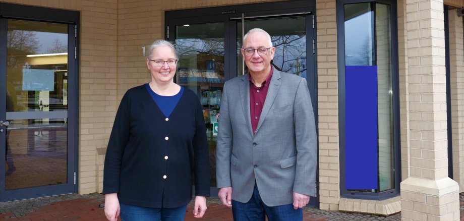 Auf dem Foto ist die neue Klimaschutmanagerin Ursula Paul zusammen mit dem Bürgermeister der Gemeinde Lohfelden, Uwe Jäger, vor dem Eingang des Rathauses zu sehen.